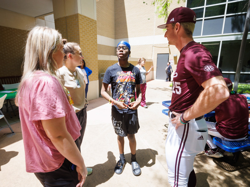 JaMelvion Jenkins, of Macon, a patient at Children's of Mississippi, chats with child life specialist Ally Holliman, left, and child life intern Sophie Patikas, and MSU pitcher Nate Dohm.