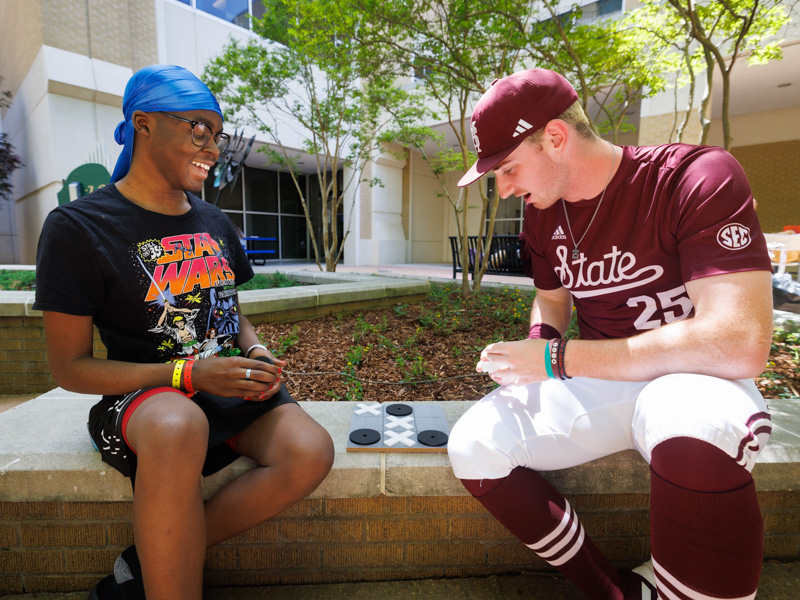 JaMelvion Jenkins, of Macon, a patient at Children's of Mississippi, plays tic-tac-toe with MSU pitcher Nate Dohm.