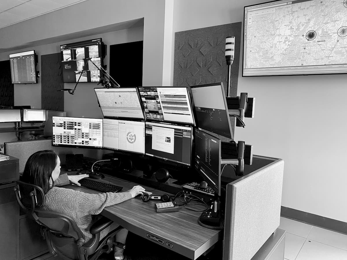 Person sits at Operations Emergency Transfer desk while viewing data on multiple screens.