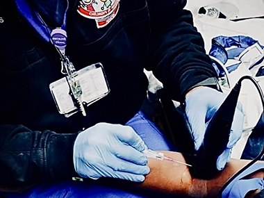 Pediatric Transport Team member inserting a syringe into a patient's arm.