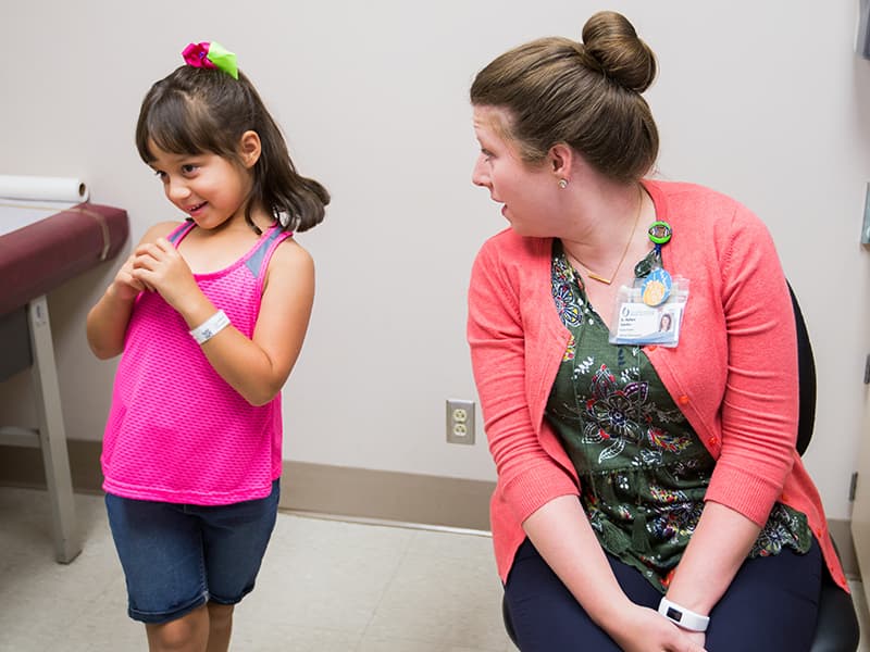 Dr. Barbara Saunders breaks the ice with her patient, Lana Puga, 6, at a UMMC child development clinic. Lana and her brother John Wesley Bishop, 4, see Saunders every four or five months, brought by their legal guardians, Pearlie and Daniel Warren, to Jackson from their home in the Mount Olive area.