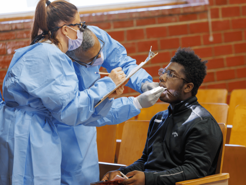 Ninth-grader, Alvin Simmons, has his teeth examined by Dr. Sreenivas Koka, dean of the School of Dentistry and Brittany Rogel, assistant professor of dental hygiene.