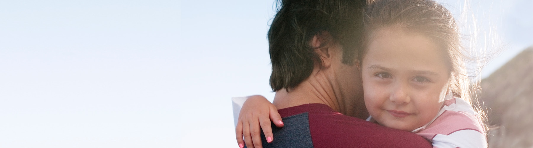 child hugging woman's shoulder