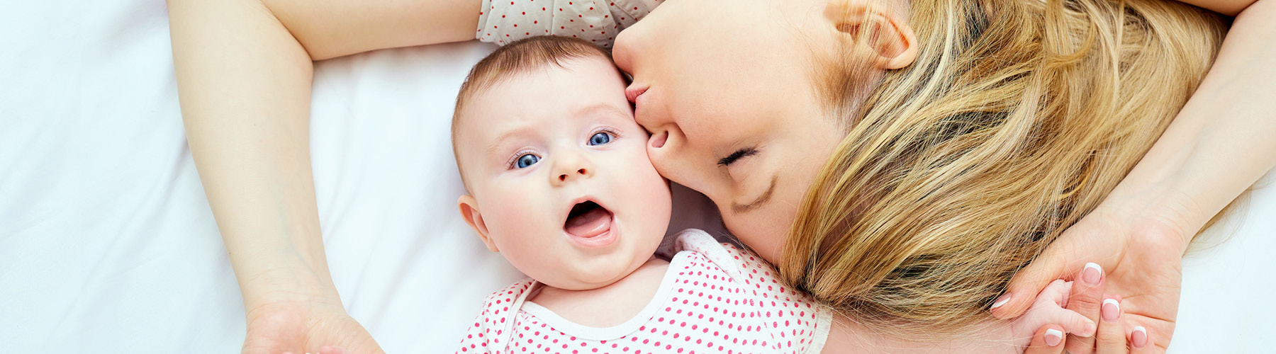 woman kissing a happy baby