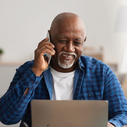 Man smiles while on the phone.