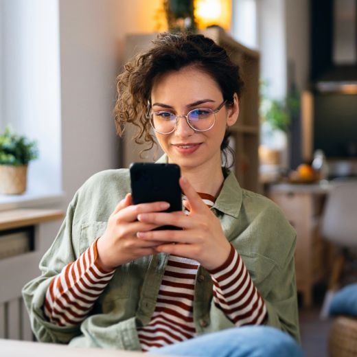 Woman types on smart phone.