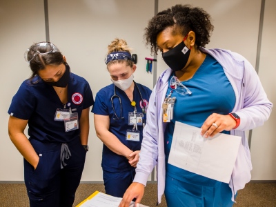 Three nursing students take part in a simulation exercise.