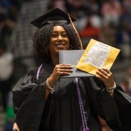 SON Graduate holding diploma and award.