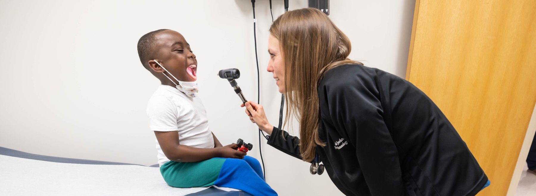 Pediatric nurse examines patient.