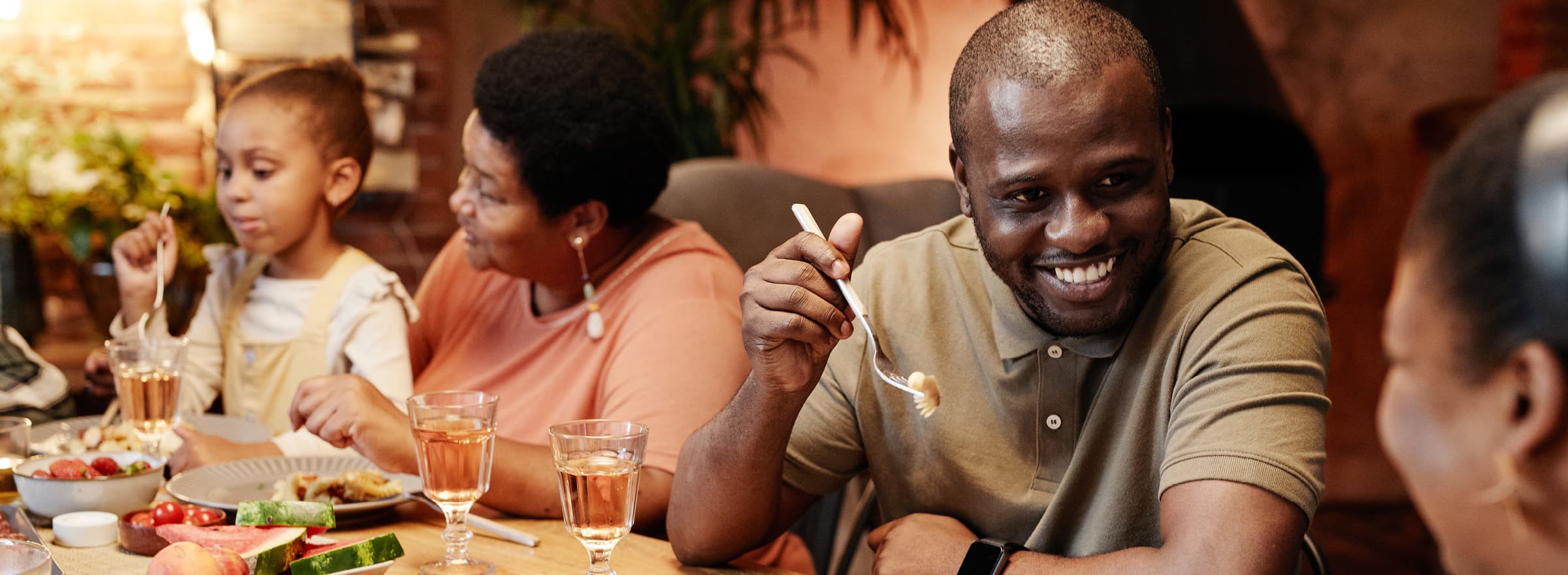 A group of people sit together at a table enjoying a meal and conversation.