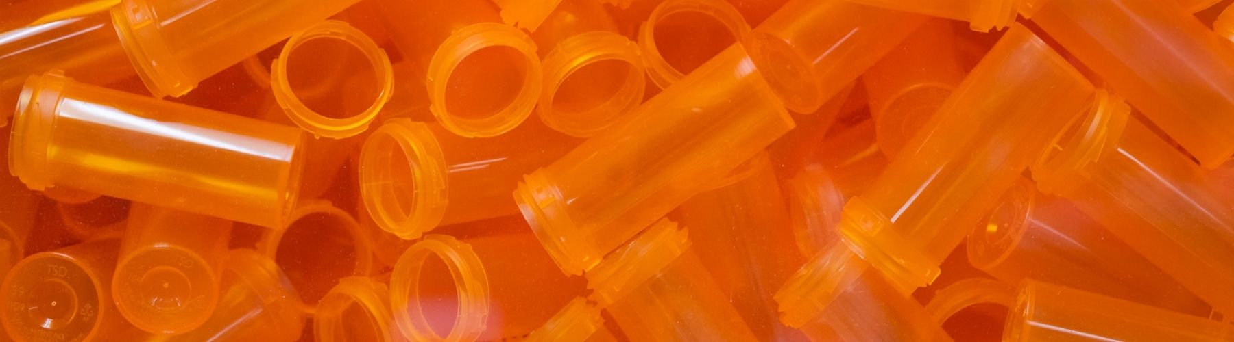 A closeup of numerous empty pill bottles.