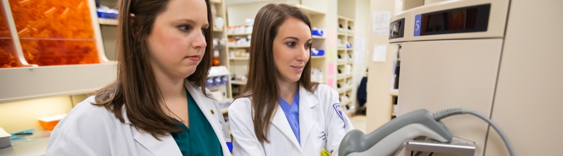 Two pharmacy workers smiling as they work.