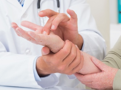 Physician examines hand.