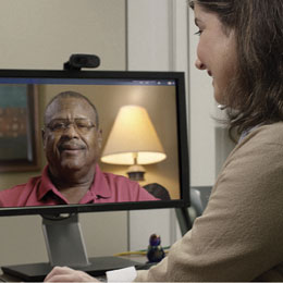 Doctor viewing Coach Leroy Henderson on monitor during telehealth session