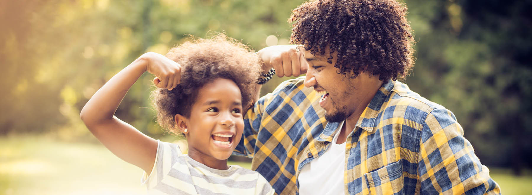 Man and child smiling and flexing their biceps