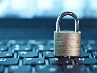 Padlock sitting on computer keyboard.