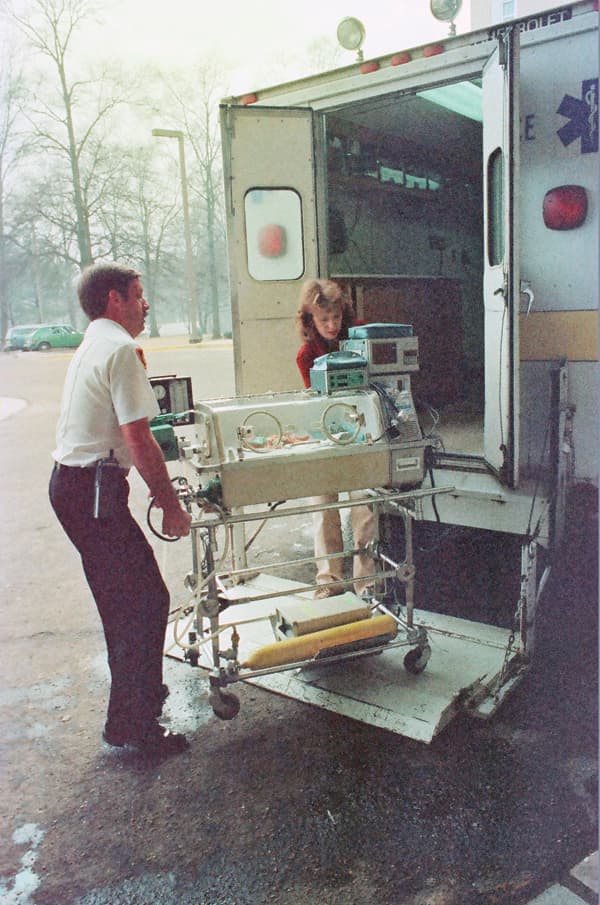 UMMC Nurse Nancy Park helps Jackson Fire Department driver Pat Kelly move an infant from the Neonatal Cradle into the Children's Hospital in 1983.