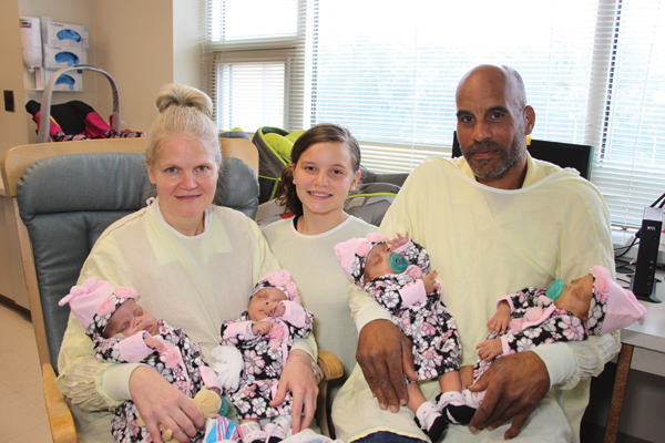 The Fugate family takes one of their first photos together. Mom Kimberly holds Kayleigh Pearl, left, and Kenleigh Rosa, big sister Katelyn sits at center, while dad Craig holds Kristen Sue, left, and Kelsey Roxanne.