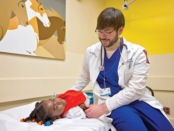 Dr. Christian Paine, assistant professor of pediatrics, examines Tisheanna Phinizee, 8, of Columbus.