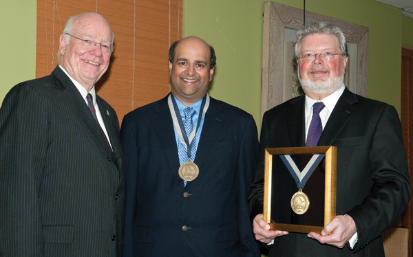 At an event to announce completed funding of the Paul H. Parker Chair of Pediatric Gastroenterology, Dr. Jimmy Keeton, left, vice chancellor for health affairs, presents medals to Dr. Paul Parker, right, and Dr. Neelesh Tipnis.