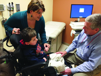 Accompanied by his mom, Modesta Carroll, Levi Washington of Vancleave visits with Dr. John Purvis at UMMC’s children’s specialty clinic in Biloxi. Levi copes with physical and mental impairments stemming from an extremely rare chromosome abnormality.