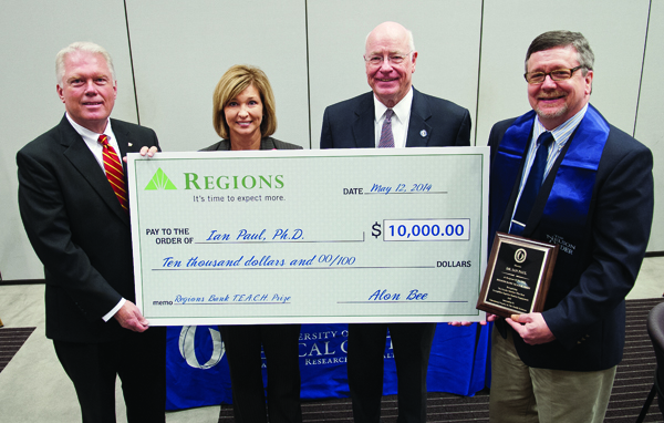 As the winner of the second annual TEACH Prize, Dr. Ian Paul, far right, professor of psychiatry and human behavior, receives a ceremonial check from Alon Bee, far left, Regions Bank Metro Jackson president. With them are Dr. LouAnn Woodward, associate vice chancellor for health affairs, and Dr. James Keeton, vice chancellor for health affairs.