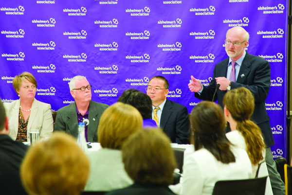 UMMC’s Dr. Tom Mosley, far right, standing, makes a point during the Alzheimer’s Research Round Table Luncheon held Aug. 12 in Jackson. Panelists include, from left, Patty Dunn, executive director of the Alzheimer’s Association/Mississippi Chapter, which co-hosted the event with the Greater Jackson Chamber of Commerce Partnership; Mike Quayle, a Jackson businessman diagnosed with Alzheimer’s; Dr. Junming Wang, UMMC associate professor of research and a member of the research team for the Memory Impairment Neurodegenerative Dementia Research (MIND) Center; and Mosley, MIND Center director and professor of geriatric medicine. Among the developments reviewed by Mosley and Wang were the discovery of a molecule that may become a biomarker for Alzheimer’s and advances in brain imaging.