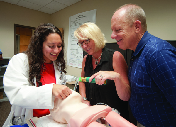 Ashley Sullivan, left, a fourth-year medical student, guides Clinton residents Melody and Rob Logan as they intubate a patient simulator during an Aug. 8 campus-wide tour that is part of Family Day, a gathering for parents and families of entering medical students. The Logans’ son Reese, a May graduate of the University of Mississippi, was among first-year students who received their white coats during a ceremony at Belhaven University.