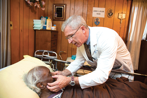 Dr. Mark Meeks offers the personal touch that home visits allow, during his examination of patient Jannie Leflore.