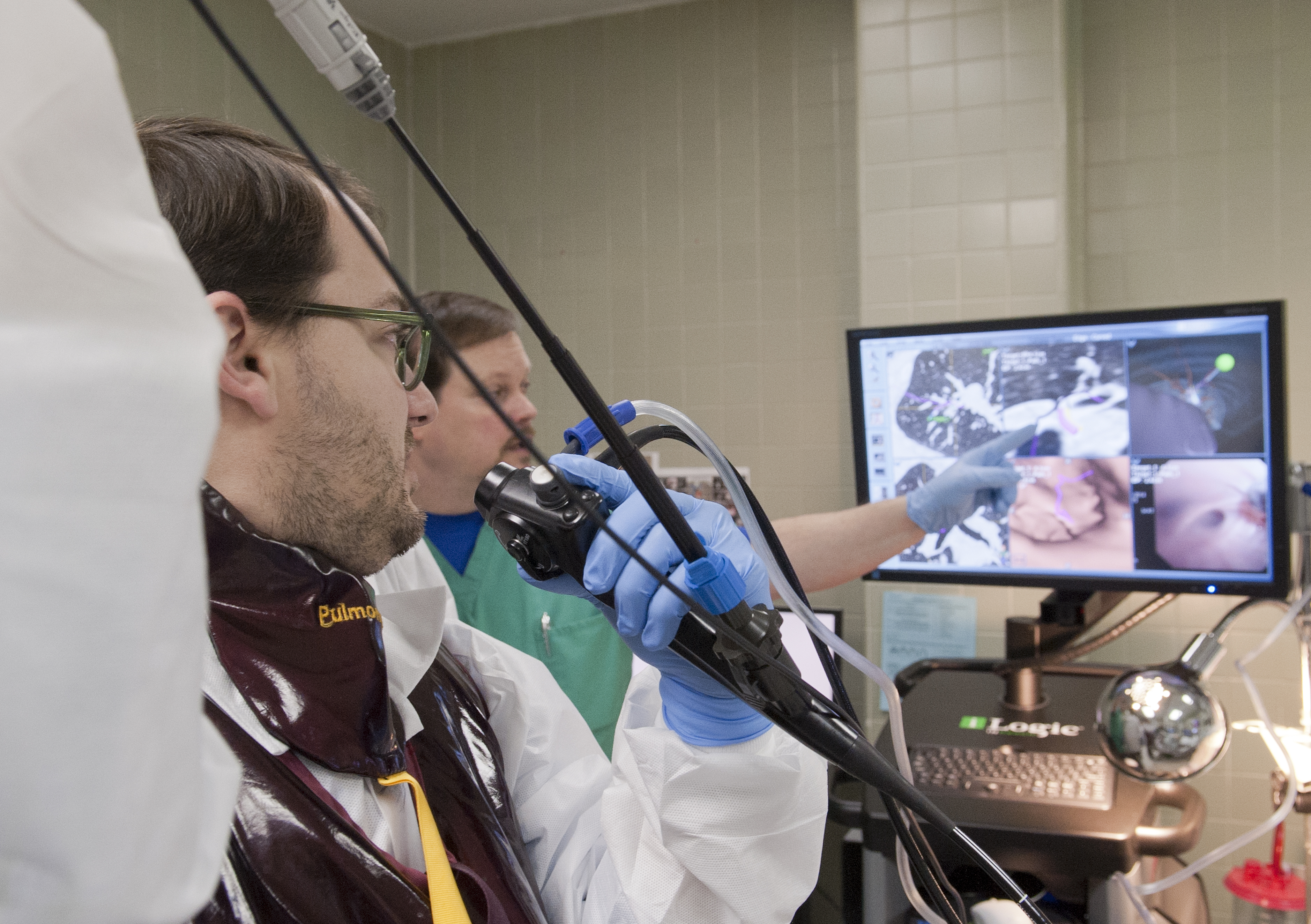 Dr. Joe Pressler, left, UMMC pulmonologist, navigates an airway during a bronchoscopy procedure as Brady Hamilton, a corporate representative from the device maker, gives guidance.