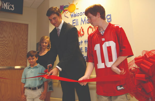In 2009,  Eli Manning cuts the ribbon for the Eli Manning Children’s Clinics – funded completely by Friends – with help from Batson patients, from left, Cameron Smyly, Aubree Jordan and Taylor Gibson.