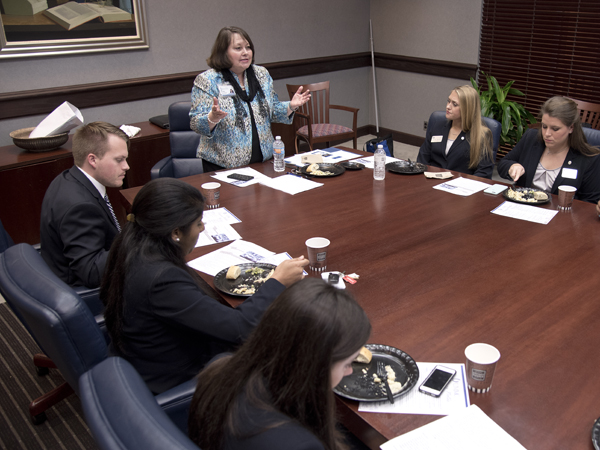 Norris explains the finer points of dining etiquette to students as part of honing the social skills they need for job interviews and networking.