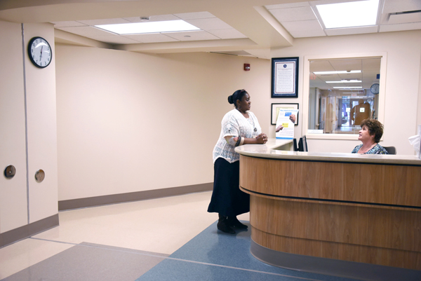 Coffee (left) confers with Jacque Ward, accounts payable clerk, at the newly designed reception desk