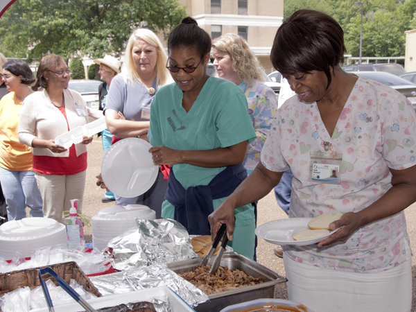 Celebrating UMMC Holmes County's 15th year in that community with a barbecue lunch are (far right) Donnie Washington, a licensed practical nurse; and Dr. Satira Perry, a physician in the hospital's family medicine clinic.