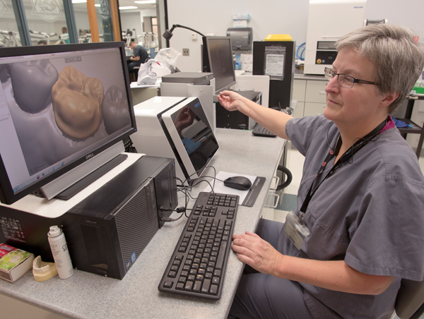 The images of computer-designed dental crown molds, displayed on the monitor of Inge Knight, instructor in the School of Dentistry, are used to produce dental crown molds.