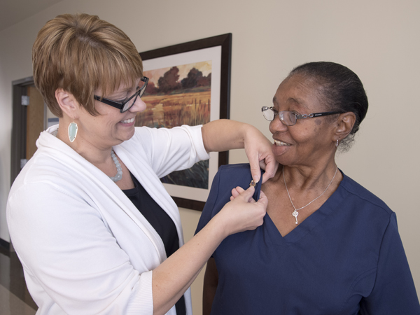 Frankie Gaines, a phlebotomist at UMMC's Adult Hematology lab at the Jackson Medical Mall, received her 50-year pin from Kim Meeker, administrator for Wiser Hospital perioperative and ancillary services.