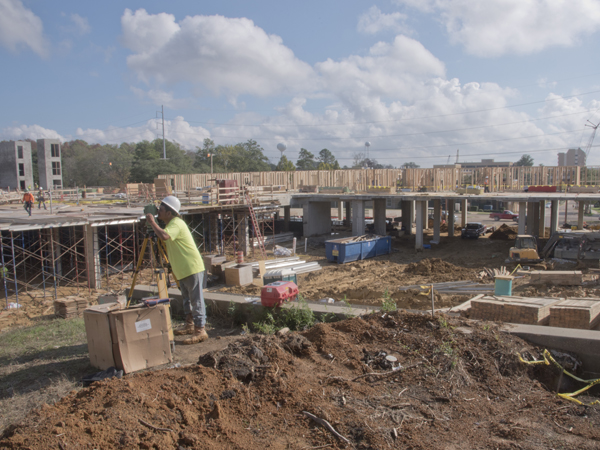 Julian Esquivel of MSE Building Co. uses equipment to survey the Meridian at Fondren site.