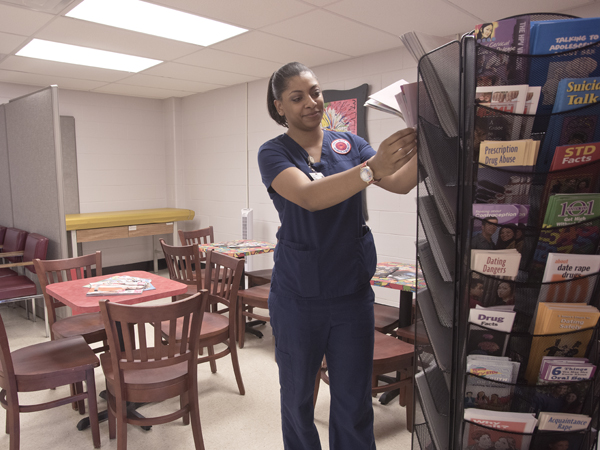 Davelin Woodard, a senior in the University of Mississippi School of Nursing, helps out by arranging health brochures at the new clinic, which will be a learning lab for nursing students.