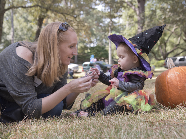 Stevie Logan sits in grass for the first time. Mom Bethany helps her feel the blades.