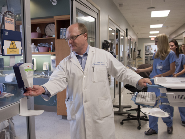 UMMC cardiothoracic surgeon Dr. Jay Shake takes time to foam his hands with sanitizer before entering a patient room on the cardiovascular intensive care unit.