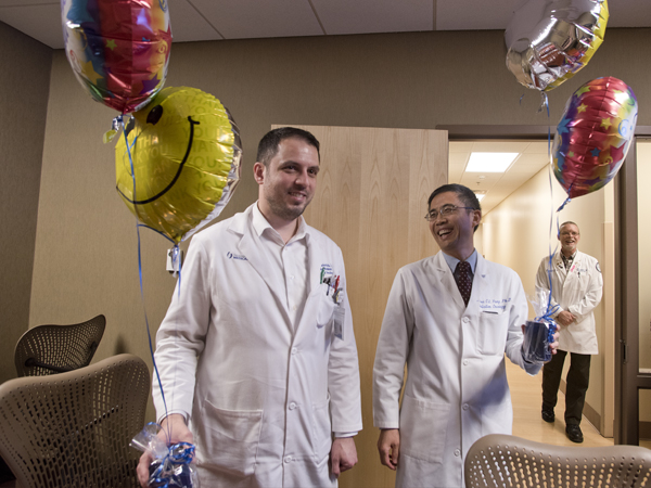 Markovich, left, and Yang were surprised with balloons and candy by coworkers and members of the AWARDS Team.