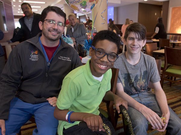 Morgan smiles with Dr. Benji Dillard, professor of pediatrics at UMMC, and his son Jacob.