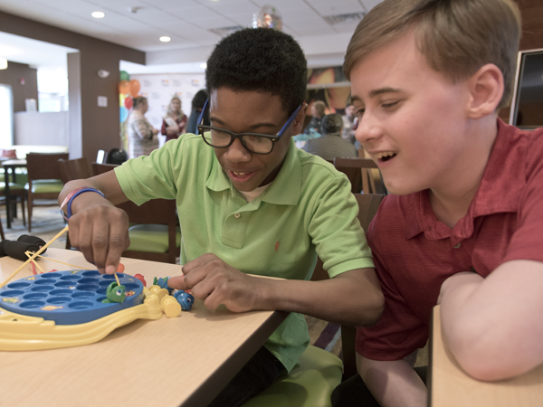 Morgan, left, and Matthew Brown, best friend and classmate at Clinton Junior High, play a game of Let's Go Fishing .