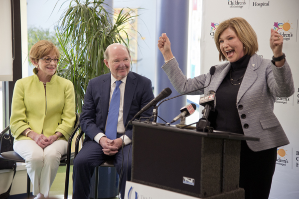 Woodward cheers at the announcement of a $10 million gift to Children's of Mississippi by Joe and Kathy Sanderson, looking on.