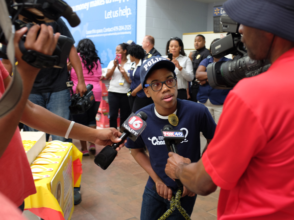 Morgan receives the celebrity treatment by Walmart employees and Jackson-area media after his arrival at the Clinton Walmart.