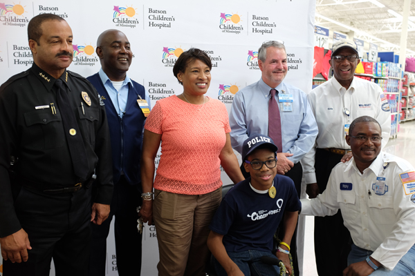 Celebrating the launch of Walmart and Sam's Club's annual fund drive for Children's Miracle Network Hospitals are, from left, Jackson police chief Lee Vance, Clinton Walmart manager Eddie Robinson, Deborah Morgan, Walmart market manager Steve Harvey, Walmart driver Billy Tingle, and, seated, Champion Jordan Morgan and Walmart driver Ricky Sharp.
