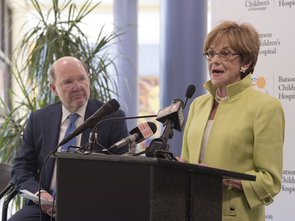 Joe Sanderson watches as Kathy speaks during the April press conference held in the lobby of the Children's Hospital to announce the fund-raising campaign.