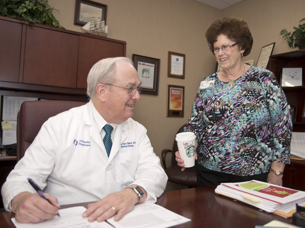 Fueled by two cups per day of Starbucks coffee, including one brought each morning by Bonita Herring, supervisor of business operations for the division, right, Thigpen has been called the most influential man in gynecologic oncology.