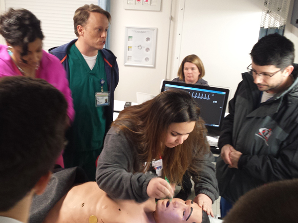 An interprofessional group takes part in an exercise simulating a youth exposed to organophosphate poison. From the right are Dr. Benji Dillard, professor in pediatric emergency medicine, Kristen Purser, SON, Eric Holland, PT resident, and Davelin Woodard, SON.