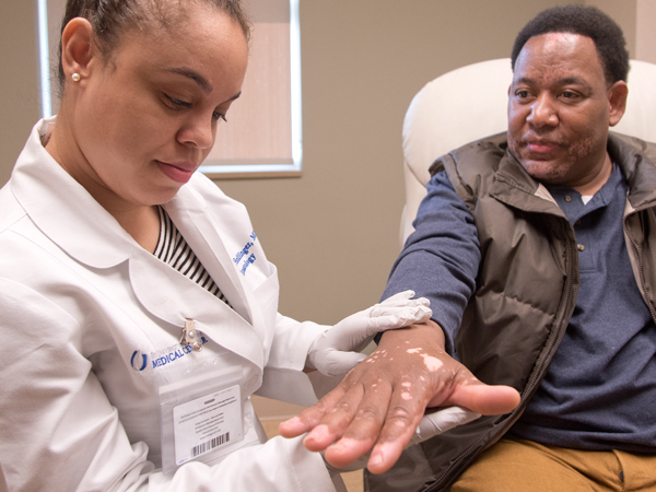 Dr. Jasmine Hollinger gauges the progress Barron Kaho has seen since she prescribed topical therapy for him.